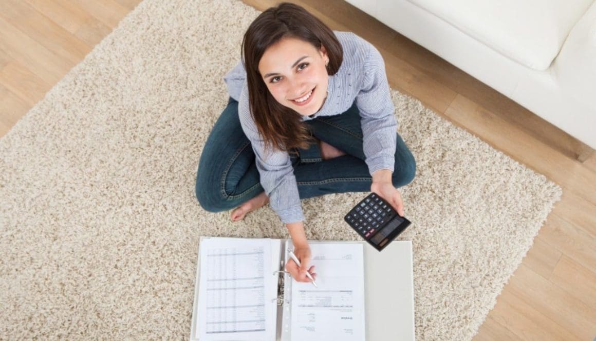 Woman Calculating Home Finances On Rug